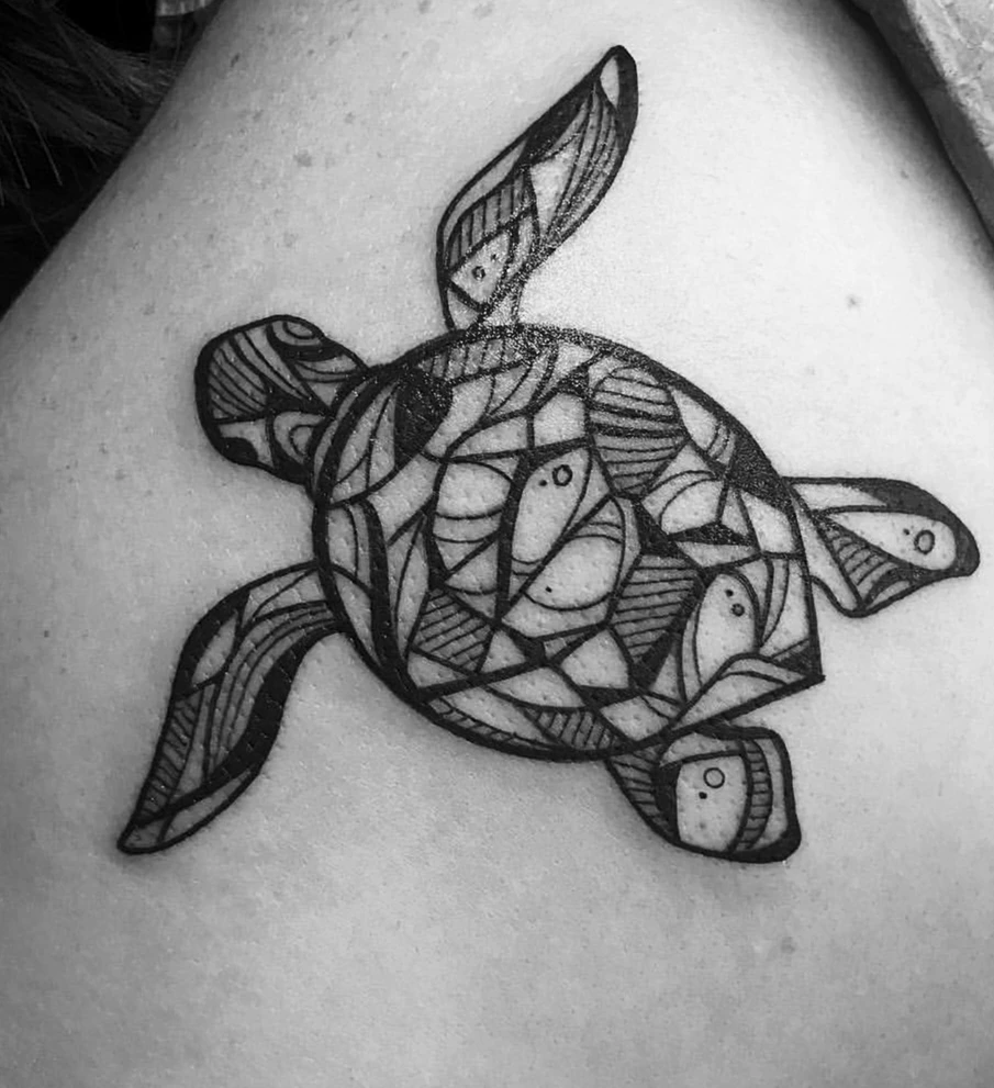 Blackwork sea turtle, its shell broken into panels that each hold a fish.
